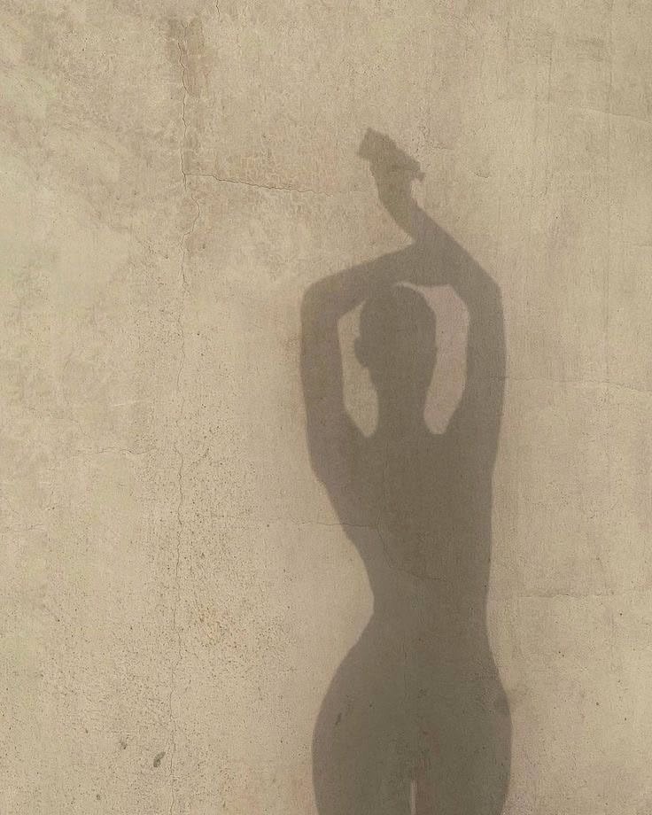 Ombre d'une silhouette féminine sur un mur, lumière douce